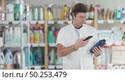 Man buyer scans qr code on tile cleaner spray label. Стоковое видео, видеограф Яков Филимонов / Фотобанк Лори