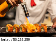 Chef cooking Salmon Foie gras roll, Fusion Japanese Cuisine food, using gas burner torch. Стоковое фото, агентство Ingram Publishing / Фотобанк Лори