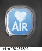 Light heart symbol made from clouds and word Air on a blue sky background through an aircraft window with copy space. Travel and transportation concept.. Airplaine window with heart symbol and word air from clouds. Стоковое фото, агентство Ingram Publishing / Фотобанк Лори