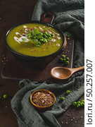 Green pea soup with linseed and pumpkin and sunflower seeds on a rustic kitchen countertop. Стоковое фото, агентство Ingram Publishing / Фотобанк Лори
