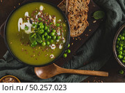 Green pea soup with linseed and pumpkin and sunflower seeds on a rustic kitchen countertop. Стоковое фото, агентство Ingram Publishing / Фотобанк Лори