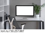 Daylight interior with white modern mock-up computer monitor on an office table, orthopaedic chair, and greenery pot on a desk, copy space. Concept of home remotely working.. Modern office working space with mock up computer screen. Стоковое фото, агентство Ingram Publishing / Фотобанк Лори