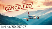 Airplane and flight cancellation. Canceled flights in Europe, Asia and USA airports. Travel cancelled. Pandemic of coronavirus. Fying passenger aircraft over the mountains at sunset and text. Covid-19. Стоковое фото, агентство Ingram Publishing / Фотобанк Лори
