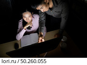 Young adult asian businessman dicuss with collegue about work late at night in their office with desktop computer. Using as hard working and working late concept. Стоковое фото, агентство Ingram Publishing / Фотобанк Лори