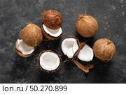 Coconuts cracked and whole on black background, top view. Стоковое фото, агентство Ingram Publishing / Фотобанк Лори