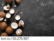 Coconut milk, whole and cracked coconuts on black background, top view. Стоковое фото, агентство Ingram Publishing / Фотобанк Лори