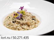 Creamy cheese risotto with mushroom and truffle oil decorate with yellow and purple flower. International italian gourmet cuisine a la carte in buffet live station. Using for food and drink industry.. Risotto. Стоковое фото, агентство Ingram Publishing / Фотобанк Лори