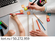 Top view of desk with child being tutored. Стоковое фото, агентство Ingram Publishing / Фотобанк Лори