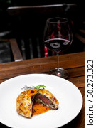 Roasted Beef Wellington with gravy brown savory sauce, international gourmet cuisine of stuff beef meat in baked bread puff with glass of red wine. Unising for recipe menu pf food and drink industry.. roasted beef wellington. Стоковое фото, агентство Ingram Publishing / Фотобанк Лори
