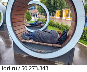 Бомжи отдыхают на современных скамейках в сквере на улице Москвы. Редакционное фото, фотограф stargal / Фотобанк Лори
