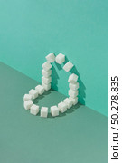 Creative corner geometric composition from sweet pressed refined sugar blocks on a duotone background in green colors with copy space.. Corner geometric composition from sweet refined sugar cubes. Стоковое фото, агентство Ingram Publishing / Фотобанк Лори