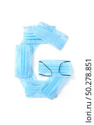 Capital letter G handmade from medical antibacterial protective blue face masks on a white background, copy space. Creative alphabet for making up new words.. Letter G made from protective medical masks on a white background. Стоковое фото, агентство Ingram Publishing / Фотобанк Лори