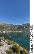 Mountainous coastline with clear blue sky and still water, suitable for background or travel design. Стоковое видео, видеограф Анастасия Золотницкая / Фотобанк Лори