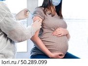 Pregnant Vaccination. Pregnant Woman In Face Mask Getting Vaccinated in Clinic. Doctor Giving Corona Virus Vaccine Injection Patient. Covid-19. Стоковое фото, фотограф Марина Демидюк / Фотобанк Лори