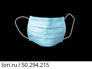 Medical antibacterial protective blue face mask on a black background, copy space. Concept of prevention from respiratory sickness and viruses.. Protective medical mask for face on a black background. Стоковое фото, агентство Ingram Publishing / Фотобанк Лори