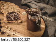 Vegan chocolate spread made of organic almond butter and organic cacao and honey, on dark rustic kitchen counter top. Стоковое фото, агентство Ingram Publishing / Фотобанк Лори