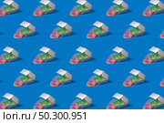 Patter made of Plastic rainbow spring slinky toy in a silver colored food container on a blue background with soft shadows, copy space. Стоковое фото, агентство Ingram Publishing / Фотобанк Лори