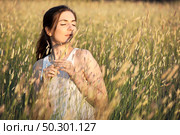 Outdoor portrait of a beautiful woman smelling flowers on a summer day. Стоковое фото, агентство Ingram Publishing / Фотобанк Лори