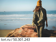 Woman with a yellow cap and walking over the cliff to see the beach. Стоковое фото, агентство Ingram Publishing / Фотобанк Лори
