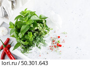 Bunch of aromatic herbs in mortar on kitchen table. Стоковое фото, агентство Ingram Publishing / Фотобанк Лори