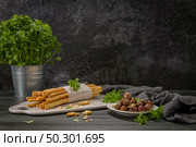 Fresh baked homemade grissini bread sticks in white ceramic tray with olive oil and basil herbs over kitchen counter top. Стоковое фото, агентство Ingram Publishing / Фотобанк Лори