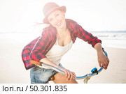 An attractive young woman riding her bicycle on the beach. Стоковое фото, агентство Ingram Publishing / Фотобанк Лори
