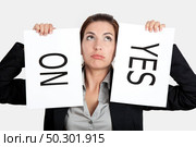 Business young woman trying to make a decision between Yes or No choice. Стоковое фото, агентство Ingram Publishing / Фотобанк Лори