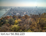 Aerial panoramic landscape above historical part of Budapest with view to river Danube and autumn trees on a forefront.. Beautiful landscape above historical part of Budapest, Hungary. Стоковое фото, агентство Ingram Publishing / Фотобанк Лори