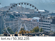Big round ferris wheel attraction, Budapest Eye on a background of old historical part of city Budapest, Hungary.. Budapest Eye, ferris wheel attraction on city background in Budapest. Стоковое фото, агентство Ingram Publishing / Фотобанк Лори