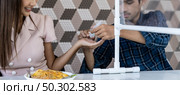 Panoramic asian man put alcohol gel hand sanitizer to his partner before eating at new normal social distance restaurant with table partition. Restaurant new normal lifestyle. Web banner crop. Стоковое фото, агентство Ingram Publishing / Фотобанк Лори