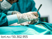 Medical team of surgeons in hospital doing surgical interventions, Process of surgery operation using medical equipment. . Стоковое фото, агентство Ingram Publishing / Фотобанк Лори
