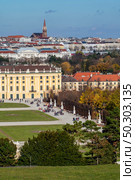 Verical cityscape with half of buildings Schonbrunn Palace in Vienna, Austria and roofs of other historical houses on a background of blue sky on an autumn day.. Cityscape with view historical buildings of Schonbrunn Palace in Vienna. Стоковое фото, агентство Ingram Publishing / Фотобанк Лори