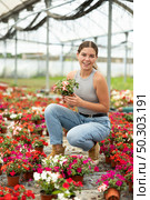 Girl chooses beautiful fresh flowers of the Balsaminaceae genus for her home. Стоковое фото, фотограф Яков Филимонов / Фотобанк Лори