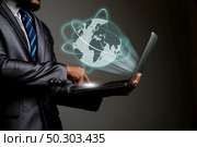Businessman holding laptop Global erupt from screen, Connecting people network concept. Стоковое фото, агентство Ingram Publishing / Фотобанк Лори