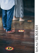 red round sign printed on ground at the font of cafe, People wearing face mask and standing keep distance in line due to coronavirus pandemic safety guideline, COVID-19 social distancing quarantine. Стоковое фото, агентство Ingram Publishing / Фотобанк Лори