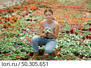 Girl chooses beautiful fresh flowers of the Balsaminaceae genus for her home. Стоковое фото, фотограф Яков Филимонов / Фотобанк Лори