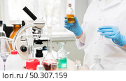 Experiments in a chemistry lab. conducting an experiment in the laboratory with humen hands. Experiments in a chemistry lab. conducting an experiment in the laboratory. Стоковое фото, агентство Ingram Publishing / Фотобанк Лори