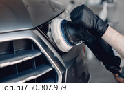 Man in a garage. Worker polish a car. Стоковое фото, агентство Ingram Publishing / Фотобанк Лори