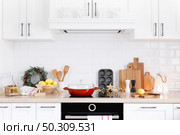 Christmas home kitchen interior with wooden worktop and kitchenware, holiday cooking background. Стоковое фото, агентство Ingram Publishing / Фотобанк Лори