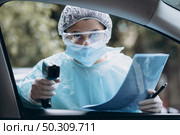 Doctor woman use infrared forehead thermometer gun to check body temperature. For virus covid-19 symptoms. Woman with the isolation gown or protective suits and surgical face masks outdoor.. Doctor woman use infrared thermometer gun to check body temperature. Стоковое фото, агентство Ingram Publishing / Фотобанк Лори