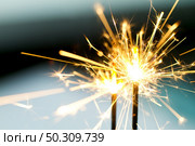 Closeup of sparks glimmering in night while fireworks burning. Стоковое фото, агентство Ingram Publishing / Фотобанк Лори