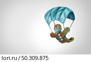 Gingerbread man with a face mask concept as a winter holiday season symbol for health and healthcare disease prevention as medical equipment parachute preventing a virus with 3D illustration elements. Стоковое фото, агентство Ingram Publishing / Фотобанк Лори