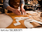 Close up of a shoemaker measuring and cutting leather in a workshop. Close up of a shoemaker measuring and cutting leather. Стоковое фото, агентство Ingram Publishing / Фотобанк Лори