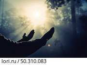 Teenage girl with praying in sunny nature. Young girl meditate in the green forest with sun lights background. Стоковое фото, агентство Ingram Publishing / Фотобанк Лори