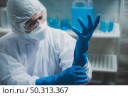 medicine specialist wearing PPE suit setting, medical people wearing surgical glove, face mask, and goggle to protection to work with coronavirus flu in hospital laboratory. Стоковое фото, агентство Ingram Publishing / Фотобанк Лори