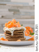Pancakes with yogurt and tangerines on a light modern kitchen counter top with oat, thyme and mint leaves. Стоковое фото, агентство Ingram Publishing / Фотобанк Лори