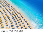 Aerial view of sea, empty sandy beach with sunbeds and umbrellas at sunny day in summer. Blue lagoon in Oludeniz, Turkey. Tropical landscape with clear turquoise water, deck chairs. Travel and leisure. Стоковое фото, агентство Ingram Publishing / Фотобанк Лори