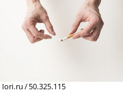 person s hand breaking cigarette white background . Resolution and high quality beautiful photo. person s hand breaking cigarette white background . High quality and resolution beautiful photo concept. Стоковое фото, агентство Ingram Publishing / Фотобанк Лори