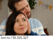 Mature couple hugging hugging each other kissing at home bedroom. Intimate Moment. Tender embrace shared between a loving middle age man and woman, husband and wife. Deep love. Low key, cinematic. Стоковое фото, фотограф Марина Демидюк / Фотобанк Лори