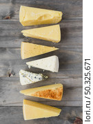 triangular cheese chunk arranged row wooden plank. Resolution and high quality beautiful photo. triangular cheese chunk arranged row wooden plank. High quality and resolution beautiful photo concept. Стоковое фото, агентство Ingram Publishing / Фотобанк Лори